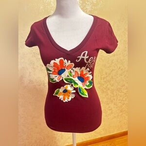 Burgundy Aeropostale v neck top. With glittery text,flower detail.